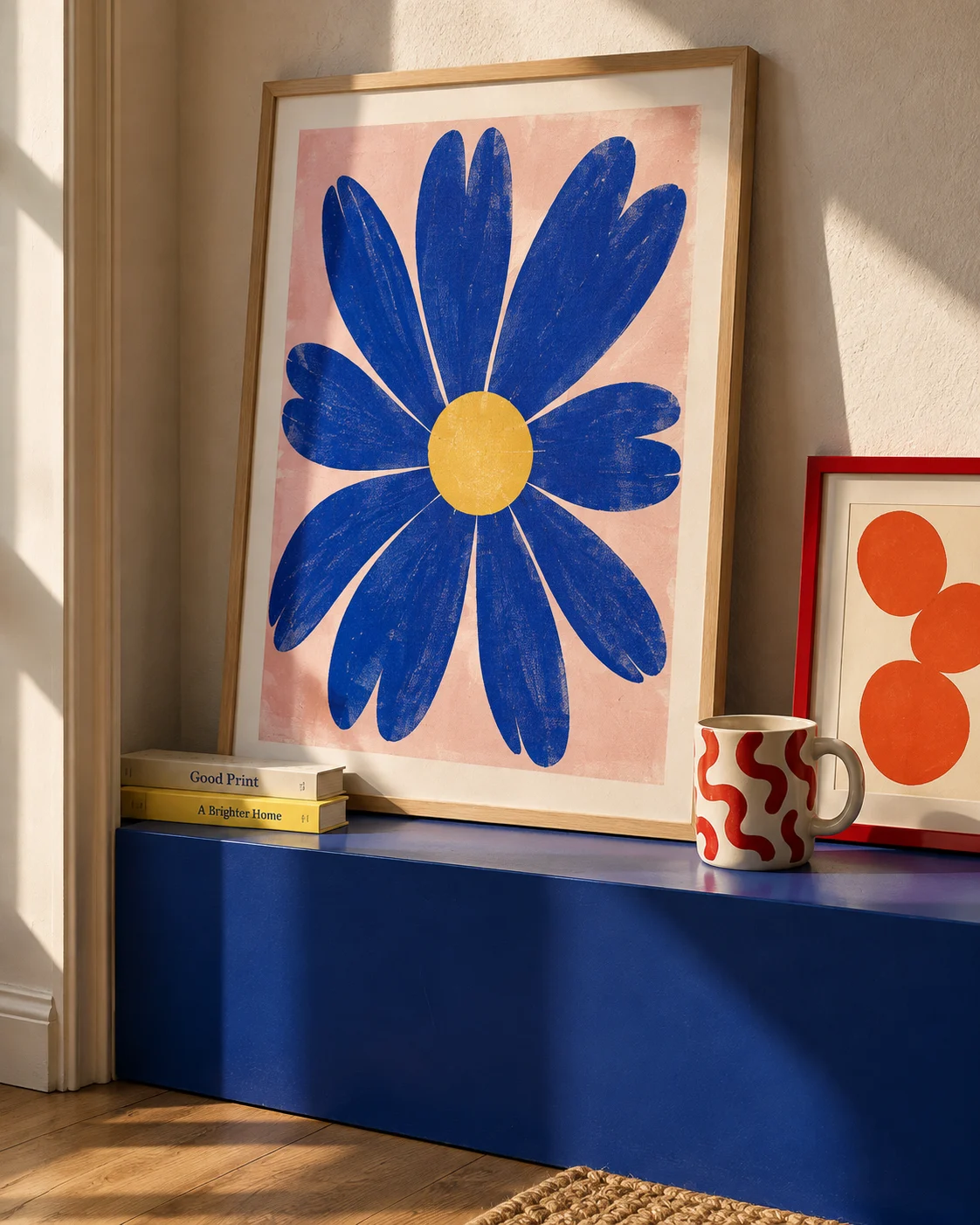 Original blue flower prints and a custom mug in a warm studio corner